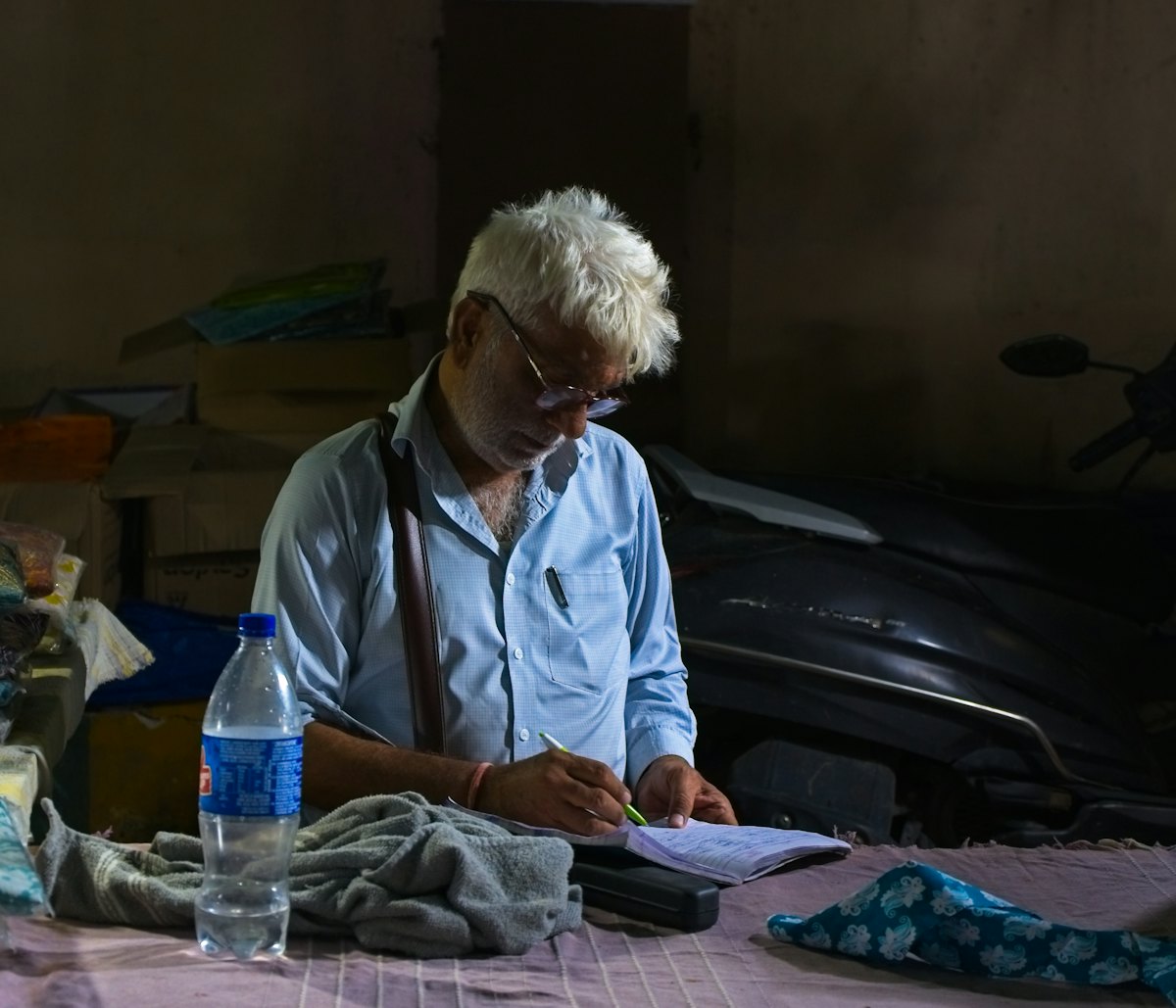 A shop owner writing up the day's records in a ledger